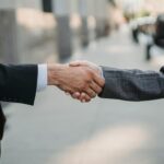 Close-up of a business handshake between professionals outdoors.